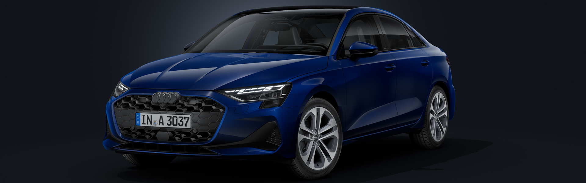 Die Audi A3 Limousine schräg von vorne auf dunklem Hintergrund.