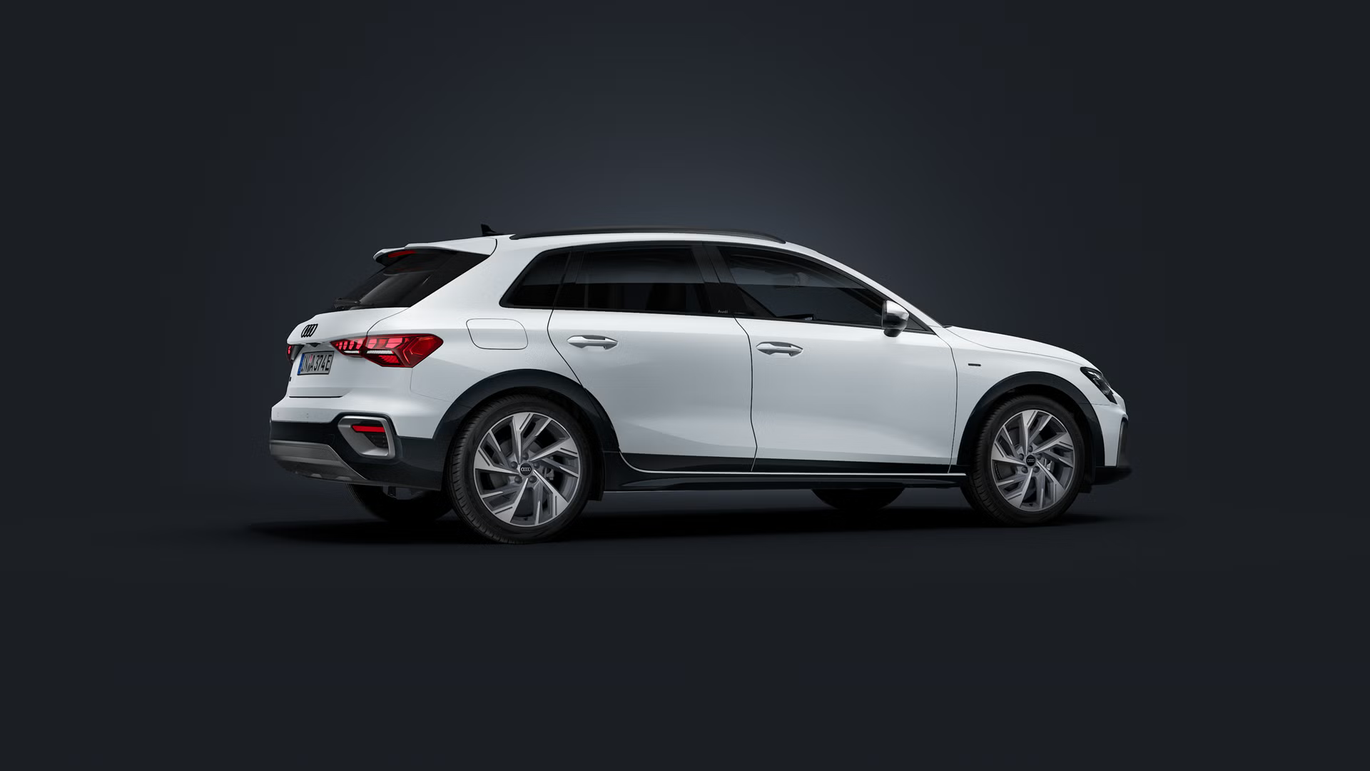 Der Audi A3 allstreet e-hybrid steht auf dunklem Hintergrund. 